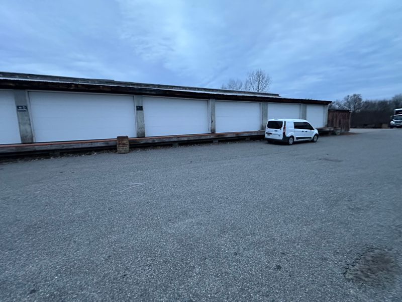 Multi-bay storage facility with white doors and Murray's service van in Massachusetts